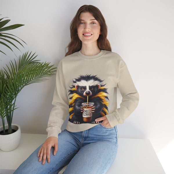 Woman wearing a beige sweatshirt with a badger graphic holding a coffee cup, sitting on a white surface with a plant in the background.