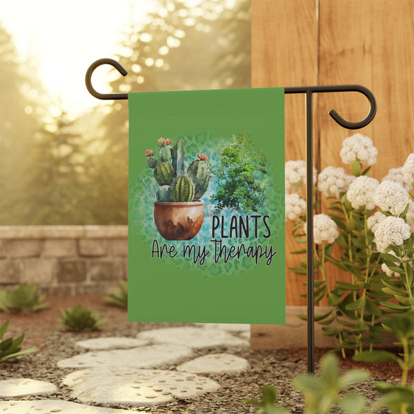 Garden flag with cactus design and 'Plants are my therapy' text, set against a garden background.