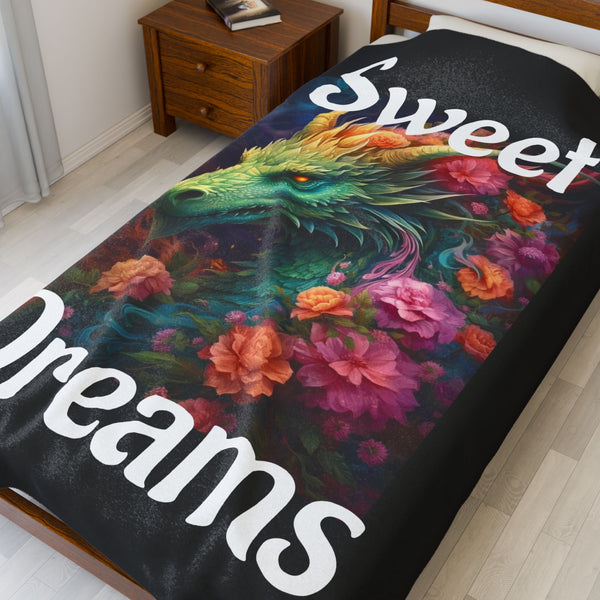 Colorful dragon and floral design on a blanket with 'Sweet Dreams' text, placed on a bed.