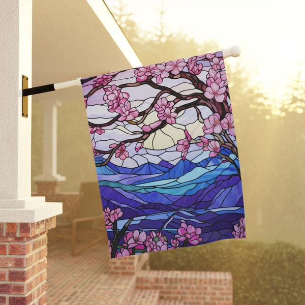 Decorative flag with cherry blossom design hanging on a pole outdoors.