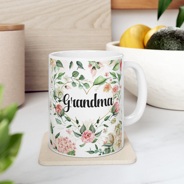 White mug with floral design and 'Grandma' text on a light surface.
