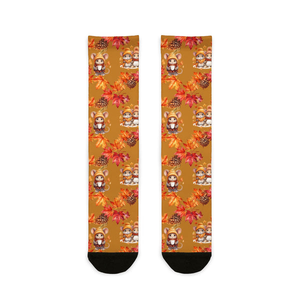 Pair of socks with autumn-themed design featuring leaves and animals on a white background