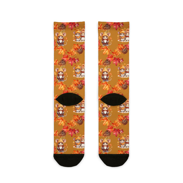 Pair of socks with autumn-themed design featuring leaves and animals on a white background