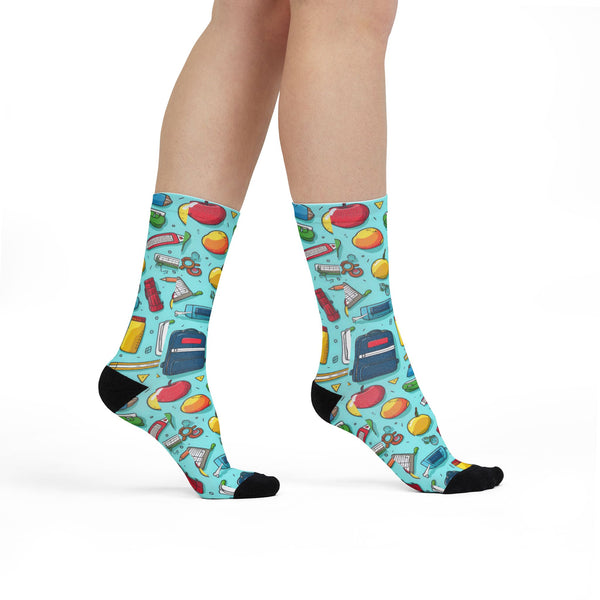Colorful socks with school-themed design worn by a person on a white background