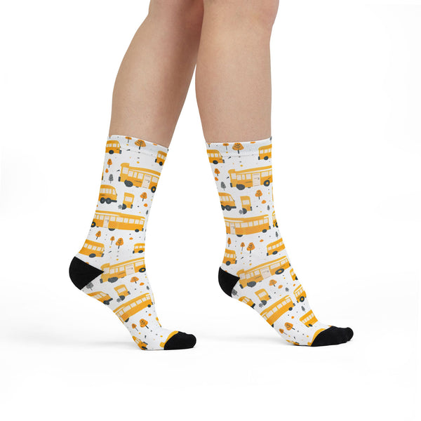 White socks with yellow school bus pattern worn by a person on a white background