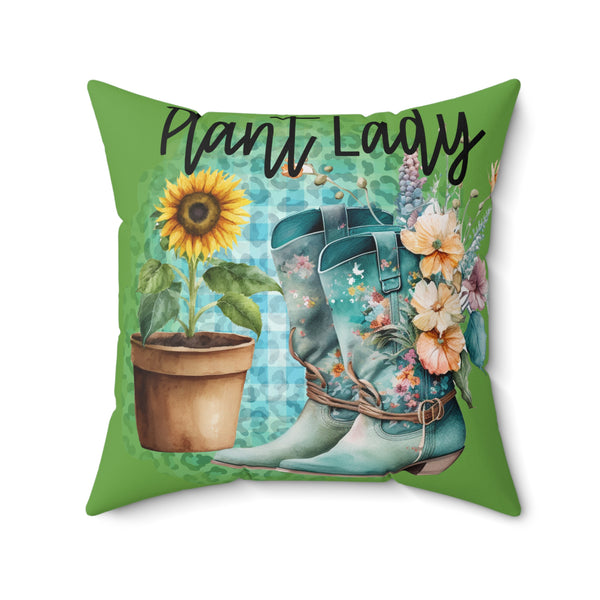 Decorative pillow with gardening-themed design featuring boots, sunflower, and flowers on a green background.