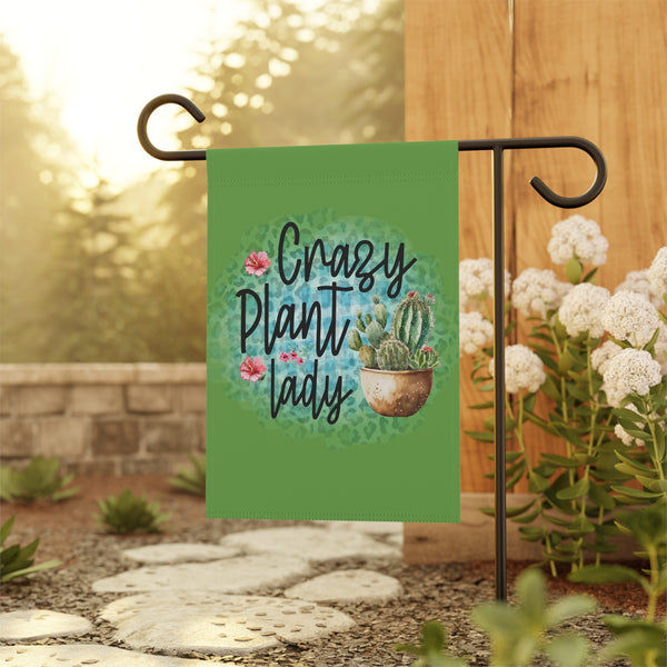 Garden flag with 'Crazy Plant Lady' text and cactus illustration on a stand outdoors.