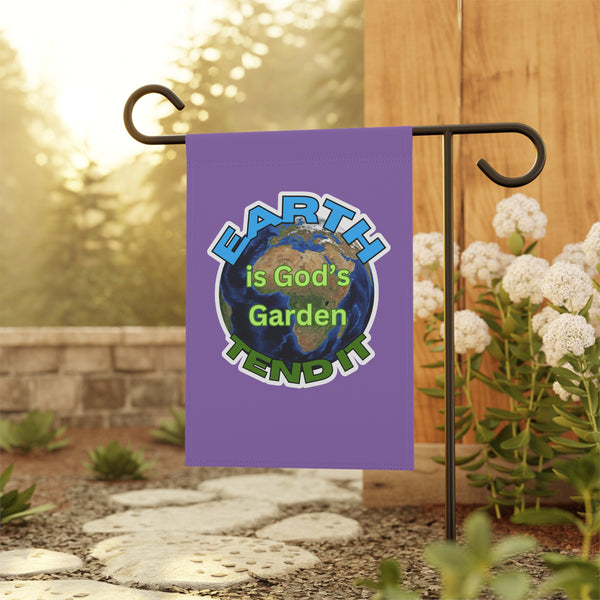 Garden flag with 'Earth is God's Garden' text on a stand with flowers and stones in the background