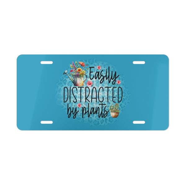 Blue license plate with floral design and text 'Easily Distracted by Plants' on a white background