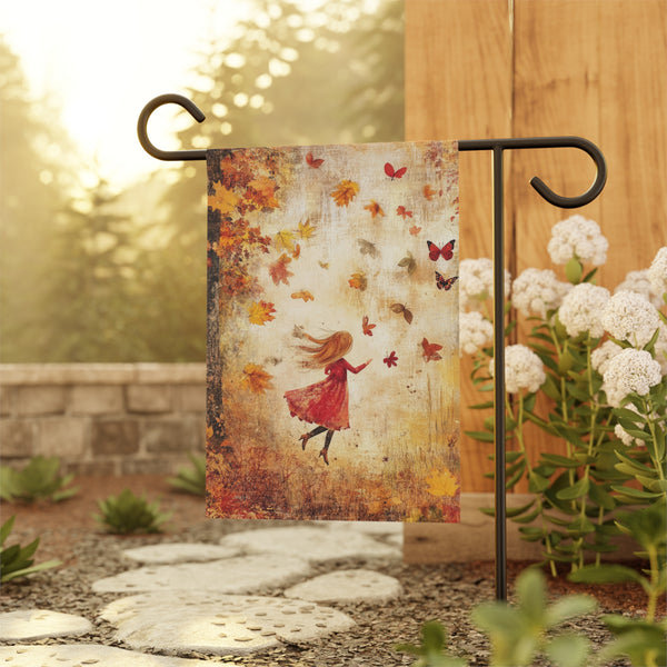Decorative garden flag with a woman in a red dress and butterflies hanging on a stand outdoors.