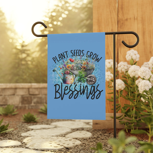 Garden flag with 'Plant Seeds Grow Blessings' text and garden imagery on a stand outdoors.