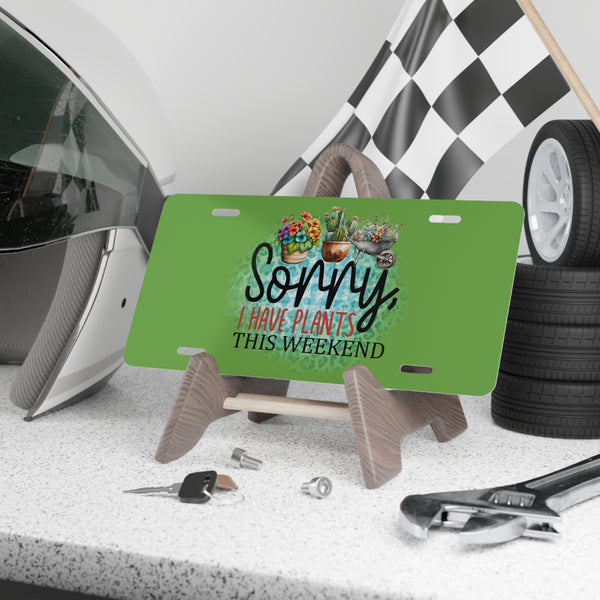 Green license plate with plant-themed text on a stand, surrounded by car parts and tools.