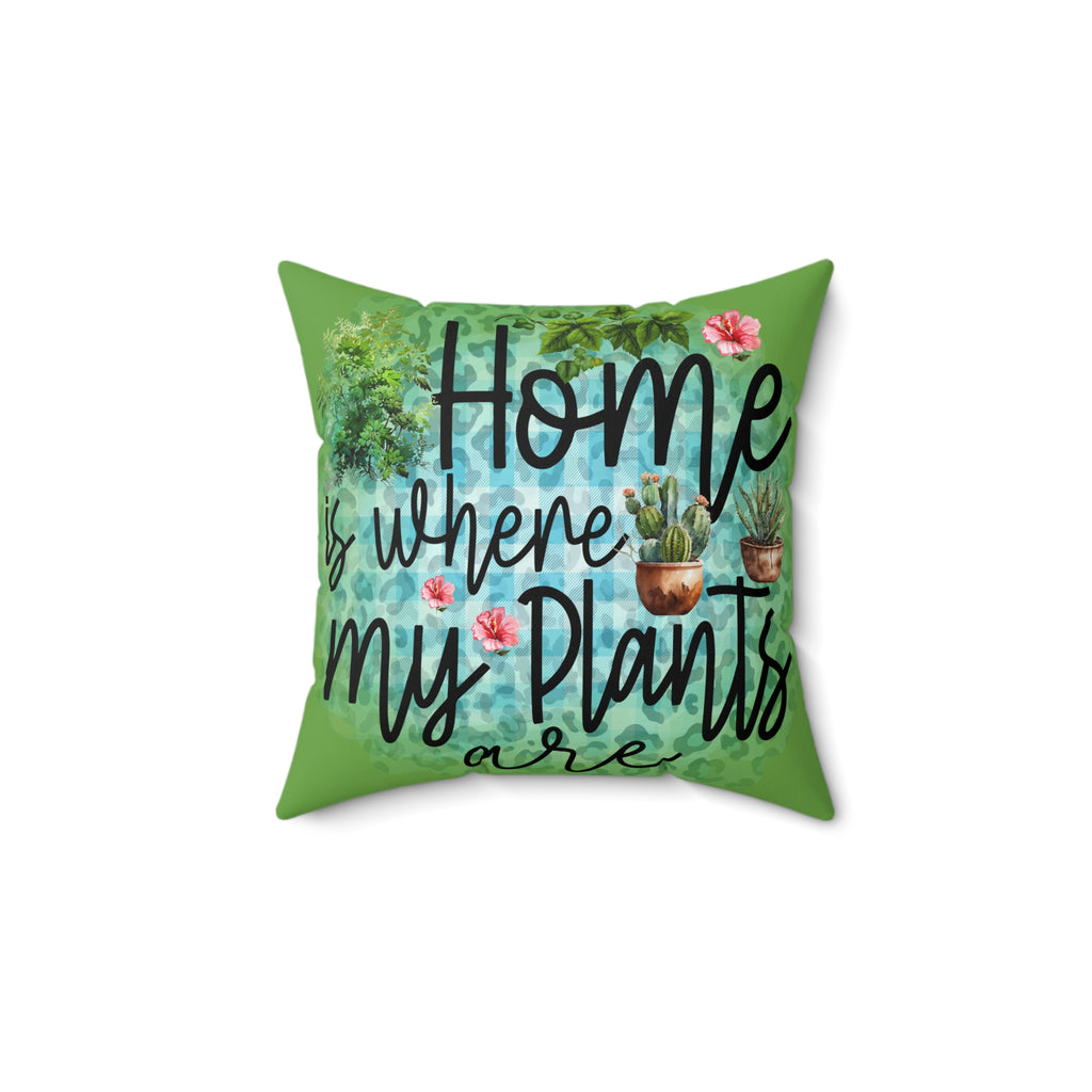 Decorative pillow with 'Home is where my plants are' text and plant illustrations on a green background.