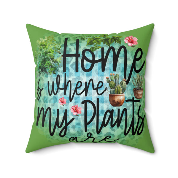 Decorative pillow with 'Home is where my plants are' text and plant illustrations on a green background.