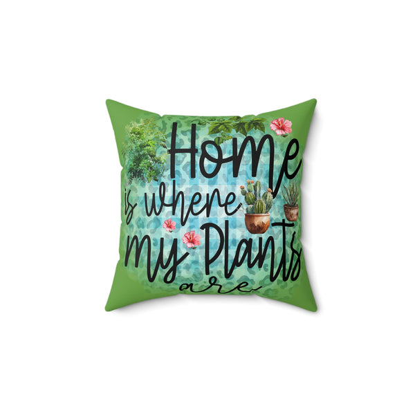 Decorative pillow with 'Home is where my plants are' text and plant illustrations on a green background.