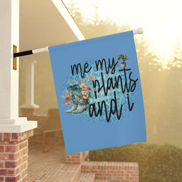 Decorative garden flag with 'me, my plants, and I' text and boots on a blue background, hanging outdoors.