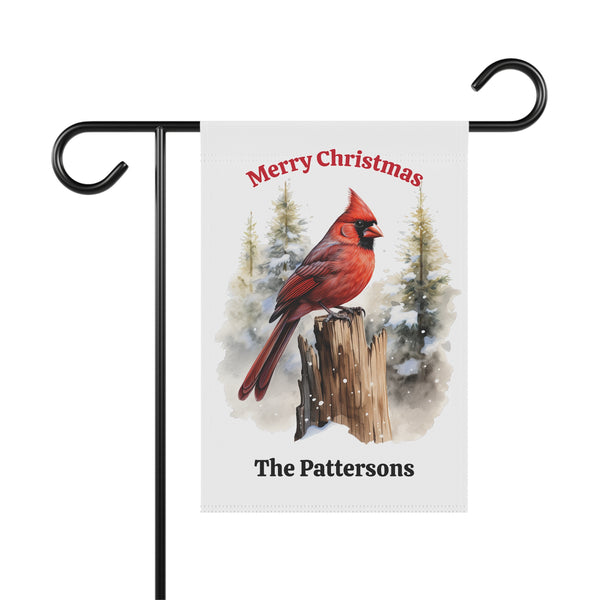 Christmas garden flag with a red cardinal on a snowy background, personalized with 'Merry Christmas The Pattersons'.