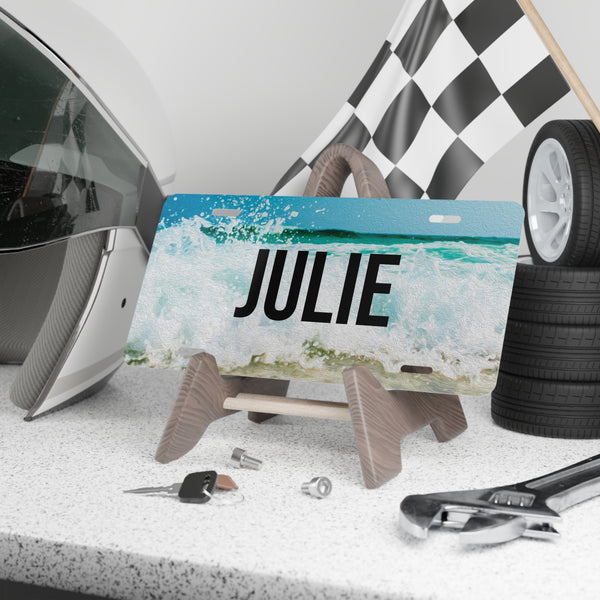 Personalized license plate with 'JULIE' on a stand, surrounded by car parts and tools.