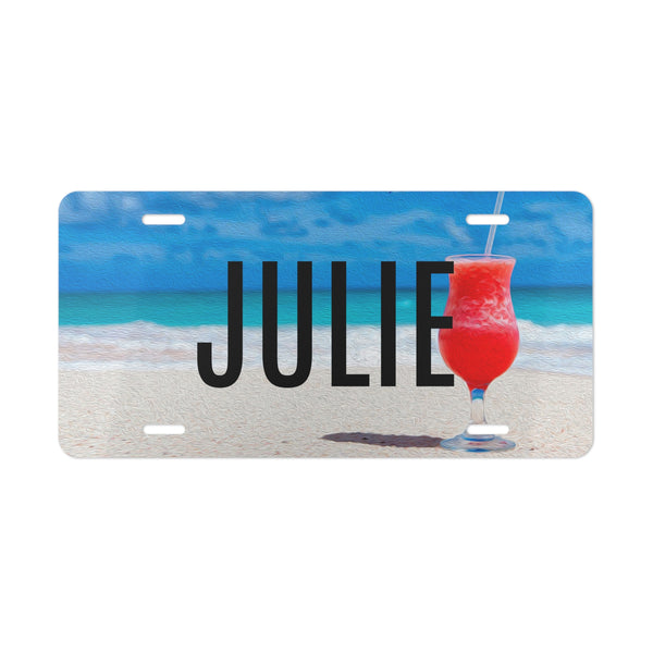 License plate with 'JULIE' and a red drink on a beach background