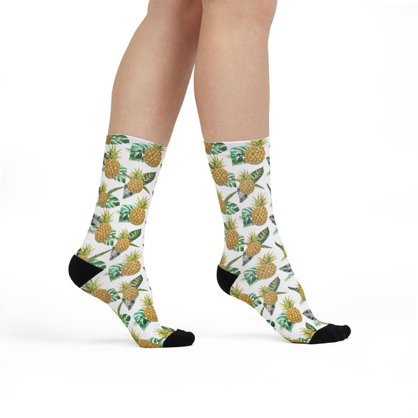 Pineapple patterned socks worn by a person on a white background