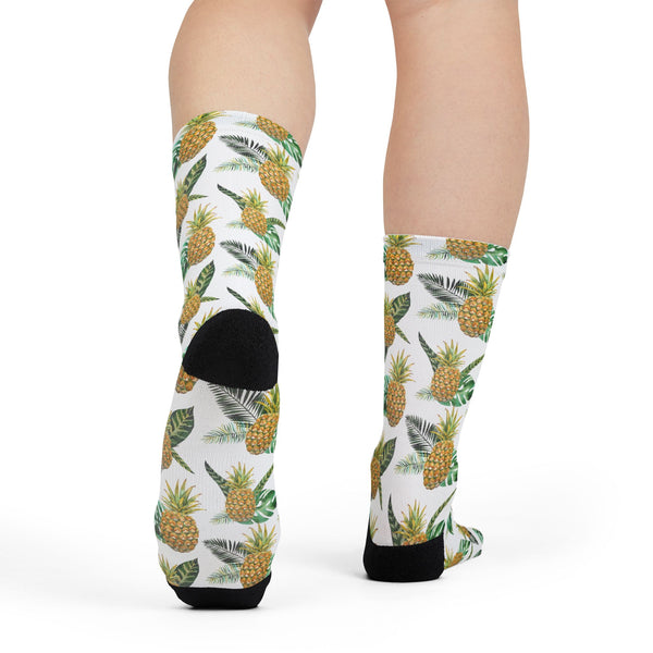 Pineapple patterned socks worn by a person on a white background