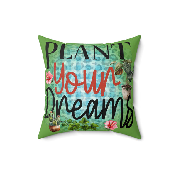 Decorative pillow with 'Plant Your Dreams' text and plant illustrations on a green background