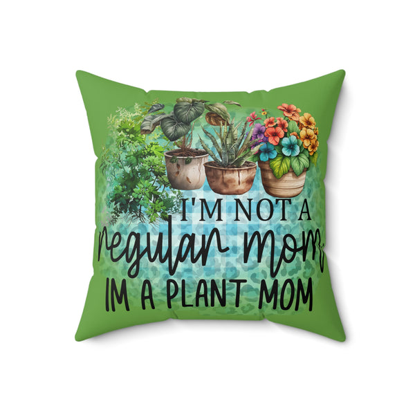 Green pillow with plant-themed design and text 'I'm not a regular mom, I'm a plant mom' on a white background
