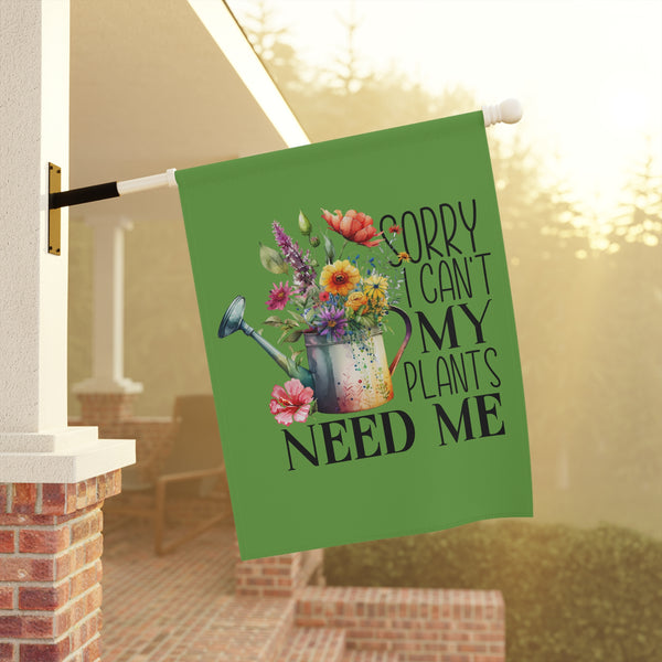 Decorative garden flag with floral design and text about plants hanging outside a house.