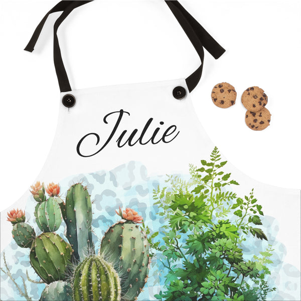 Apron with cactus design and 'Julie' printed on it, accompanied by cookies.