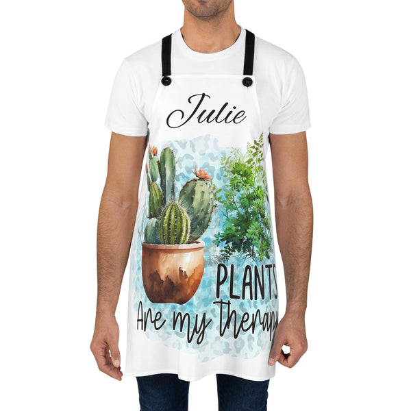 Person wearing a white apron with plant-themed design and text