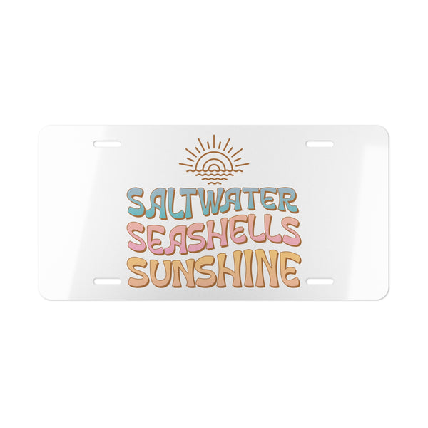License plate with 'Saltwater Seashells Sunshine' text and sun graphic on a white background