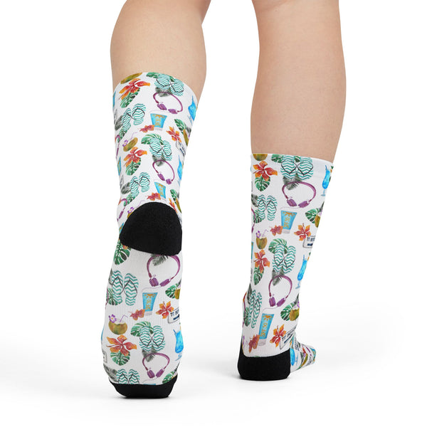 Colorful socks with floral and cup design worn by a person on a white background