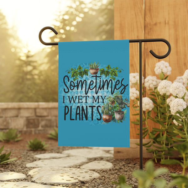 Garden flag with plant-themed text and illustrations on a stand outdoors.