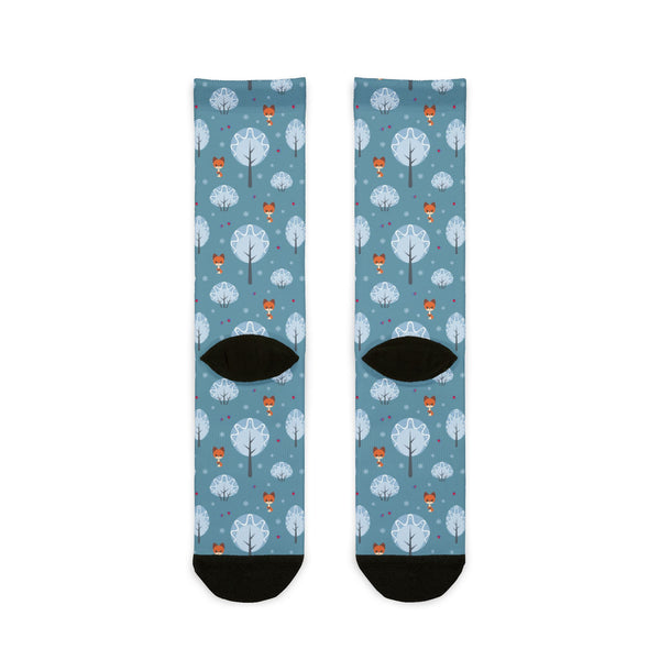 Pair of socks with a pattern of trees, birds, and hot air balloons on a blue background.