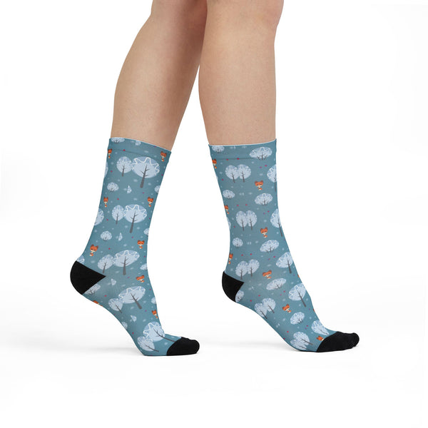Blue socks with tree pattern worn by a person on a white background