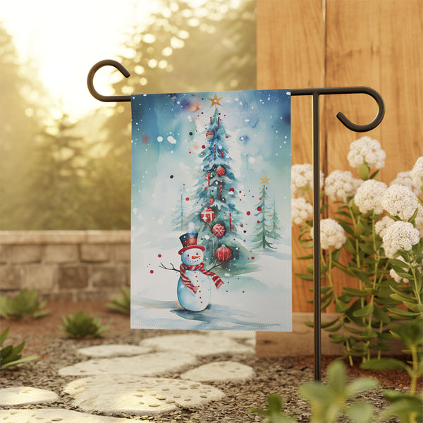 Decorative garden flag with a snowman and Christmas tree design, displayed outdoors.