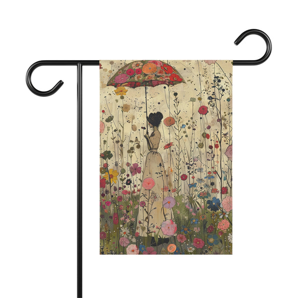 Decorative garden flag with a woman holding an umbrella amidst flowers, mounted on a black flagpole.