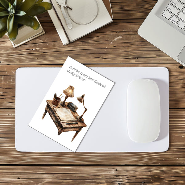 Desk setup with a mouse pad, mouse, and decorative card on a wooden surface.
