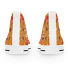 White sneakers with a colorful fall-themed pattern on the back, including pumpkins and leaves.