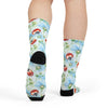 Colorful socks with ladybug and floral pattern worn by a person on a white background