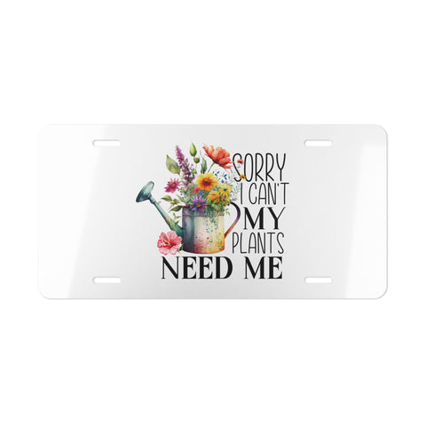 License plate with floral design and text 'Sorry I can't my plants need me' on a white background