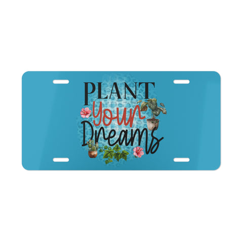 Blue license plate with 'Plant Your Dreams' text and plant illustrations on a white background