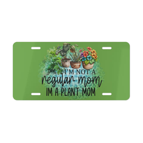 License plate with plant-themed design and text 'I'm not a regular mom, I'm a plant mom' on a green background.