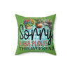 Green pillow with plant-themed text and illustrations on a white background