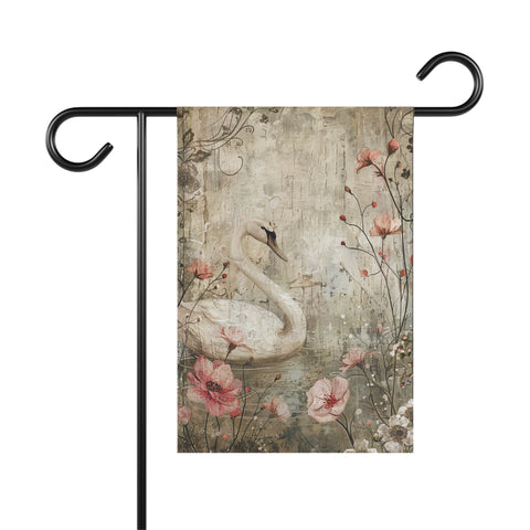 Decorative garden flag with a swan and floral design on a wooden background, attached to a black flagpole.