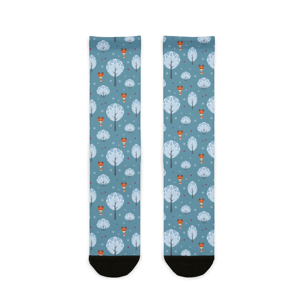Two socks with a pattern of trees and hot air balloons on a blue background.