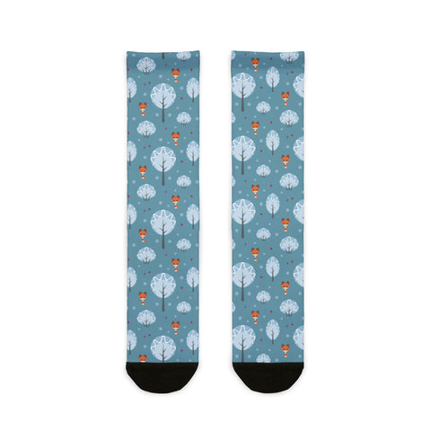 Two socks with a pattern of trees and hot air balloons on a blue background.